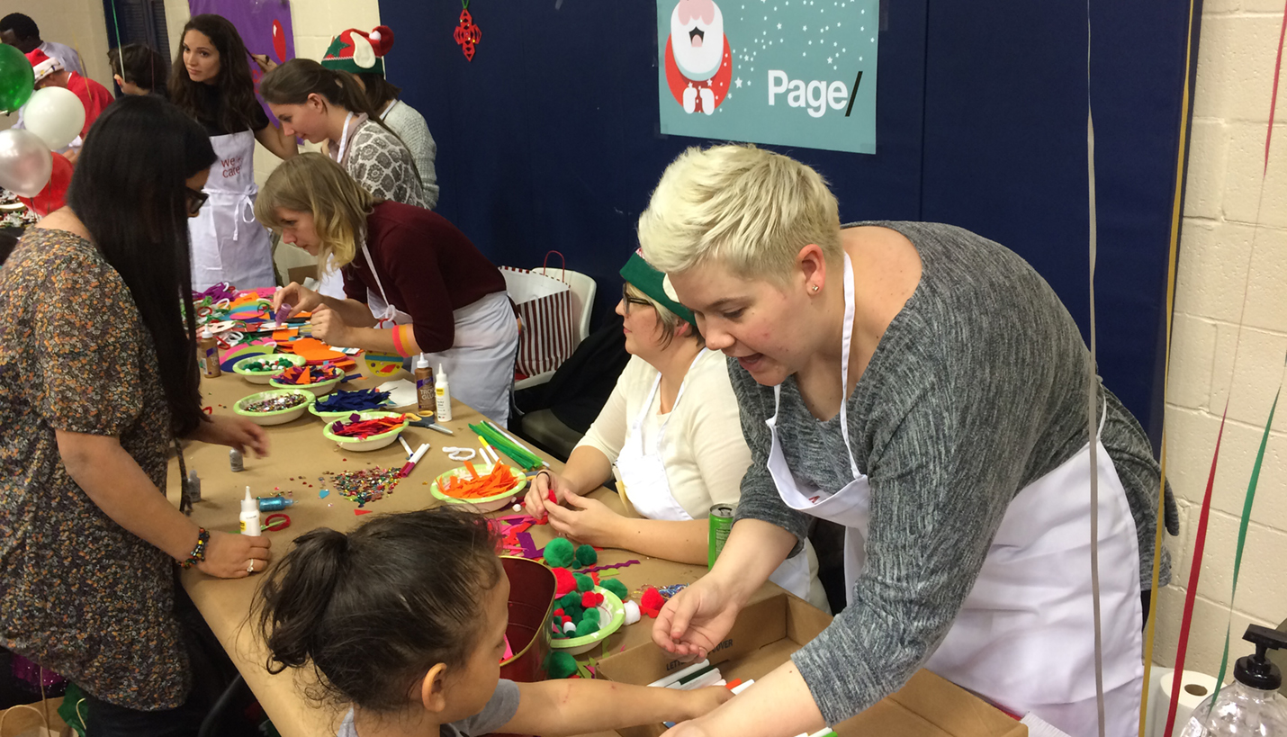 Katherine Hobbie helps a child during We Care to make a Christmas craft present. Not pictured: Hilary Bales-Morales, Elizabeth Chen, Lauren Gault, Megan Girvan, Aimee Burmaster Hicks, Crystal McMahon, Monica Serowski and Wenguel Yohannes. - 