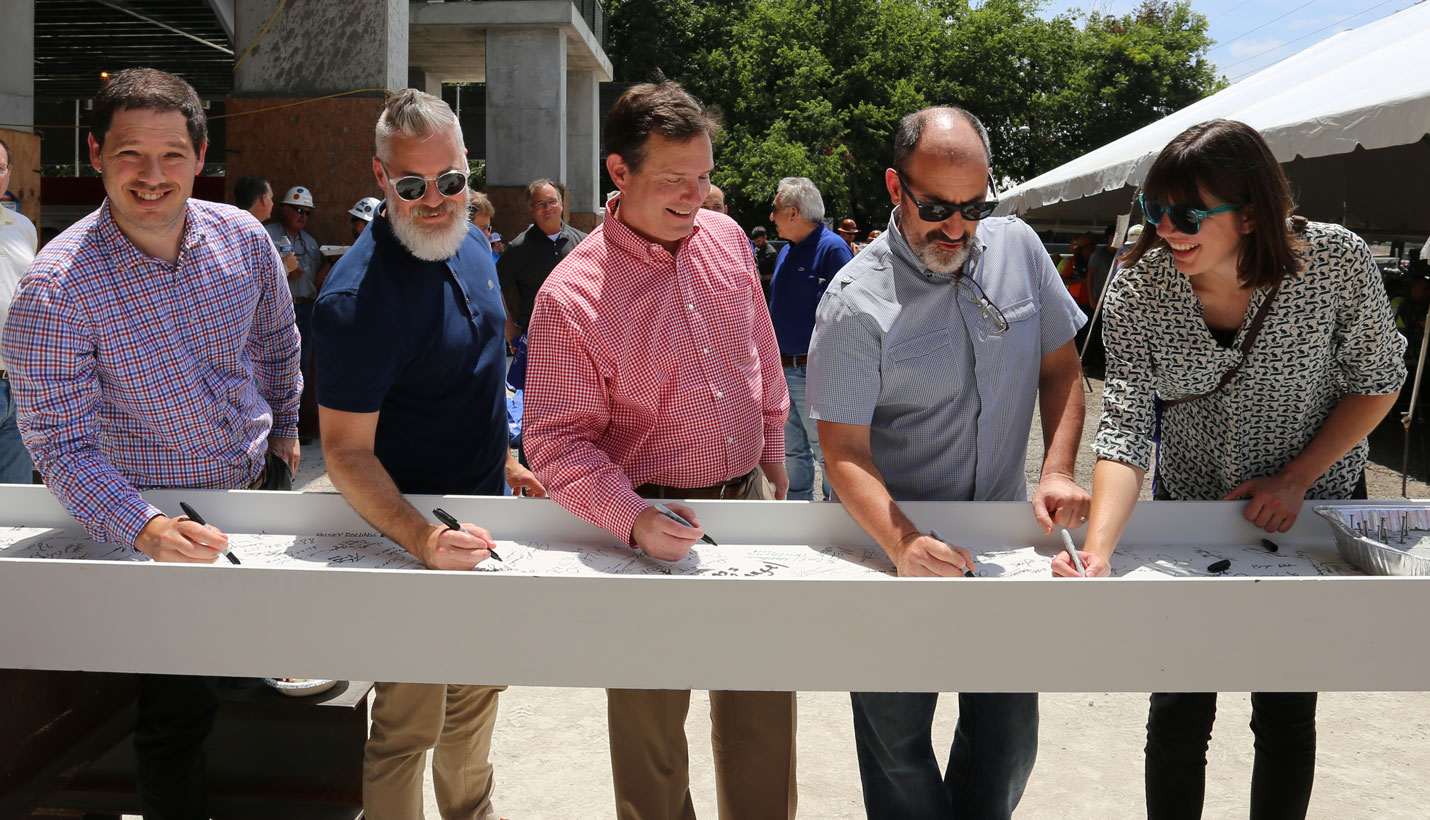 Pagers Jacob George, Brandon Townsend, Bob Burke, Daniel Brooks and Shelby Blessing sign beam. - 