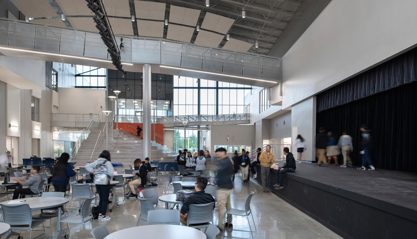 The central common area at Houston ISD High School for Law and Justice includes dining, performing (debate), gathering and circulation spaces. Intersecting spaces enable clear lines of sight across activities to reduce hidden, unsupervised spaces. - © Mariella & Luis Ayala