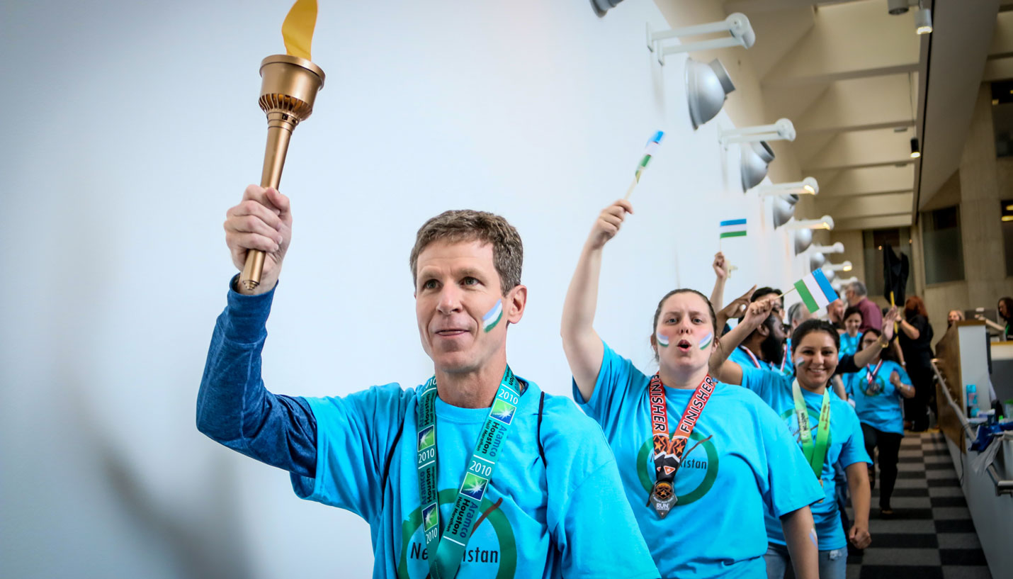 Page Senior Project Manager Brian Gray leads the parade bearing the Olympic Torch. - Andy Phan