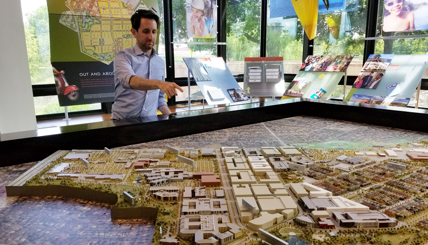 Page Designer Jonathan Schwartz points to projects on a model of the Mueller District. - Page