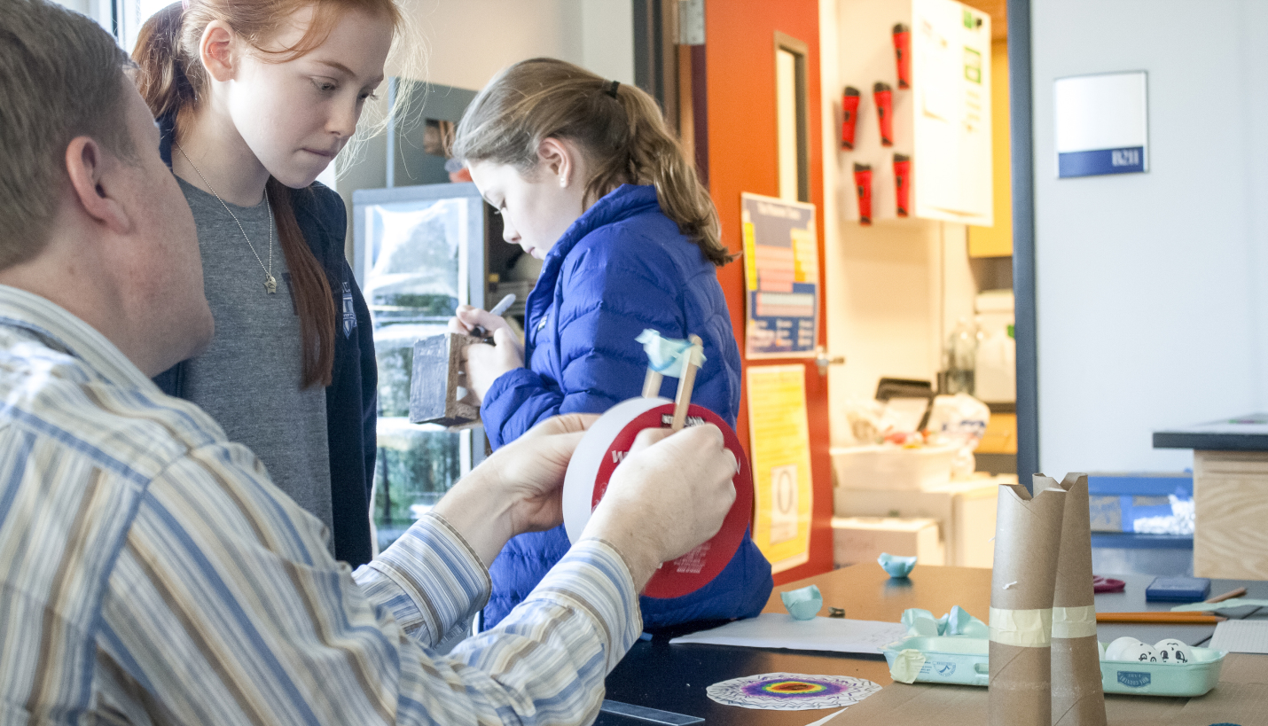 Project designer Chad Johnson studies a Trinity Episcopal student's theoretical concept with her during the school's annual STEAMFest. - Page