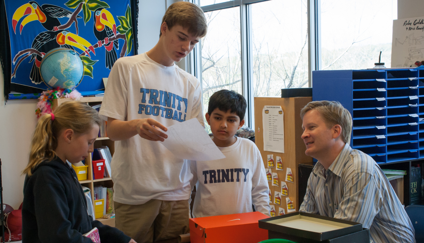 Chad Johnson, project designer, listens to a Trinity Episcopal student explain his team's STEAM design. Groups of students from multiple grades formed each team. - Page