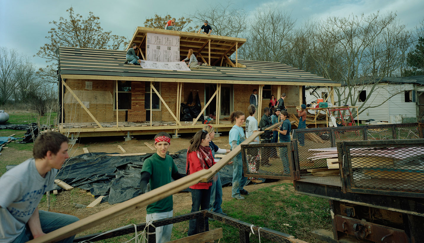 Katie Woods, third from the front in the red jacket, and her classmates unload building supplies for Rose Lee Turner's house. - © Timothy Hursley, courtesy of Auburn University Rural Studio