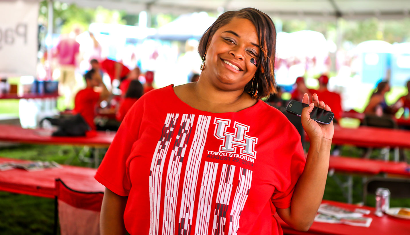 Tiffany Tucker shows the revised neckline of her Villalobos-designed T-shirt at the Page Tailgate party at the inauguration of TDECU Stadium. - Andy Phan, Page Director of Visualization